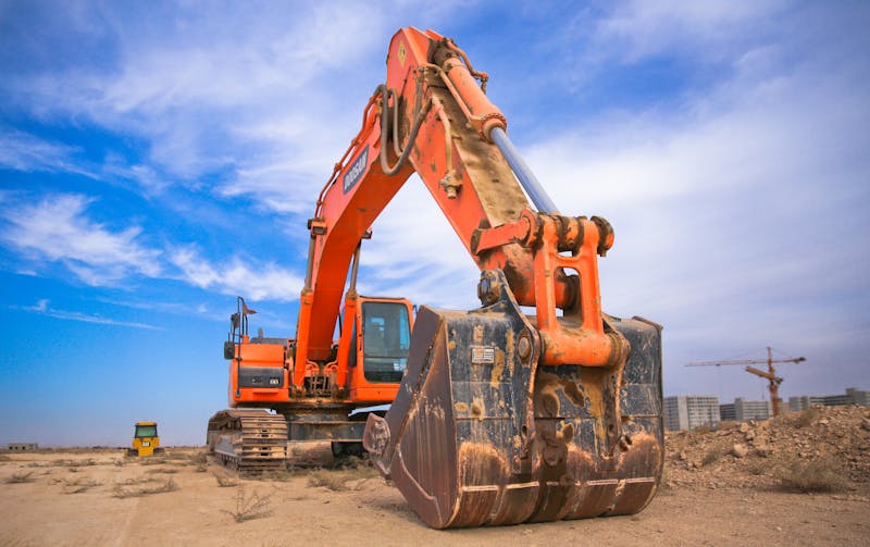 Hydraulic excavator boom and cylinder showing heavy equipment hydraulic components and hose routing